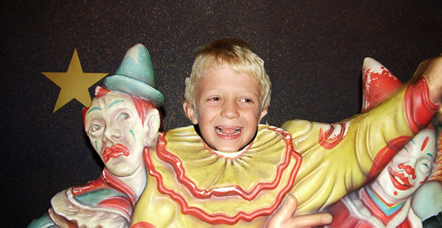 A little boy dressed as a clown.